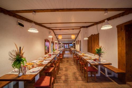 a long dining room with long tables and chairs at Domacinstvo Cikic Zasavica in Zasavica