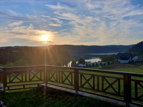 a view of the sunset from a wooden bridge at Dom na Wzgórzu SŁOŃCE na wyłączność JACUZZI ELEKTRYCZNE SAUNA ROWERY in Zawóz