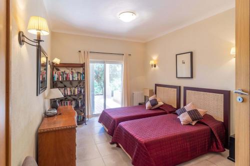 ein Schlafzimmer mit 2 Betten und einem Bücherregal in der Unterkunft Villa Meijer Gramacho Golf in Estômbar