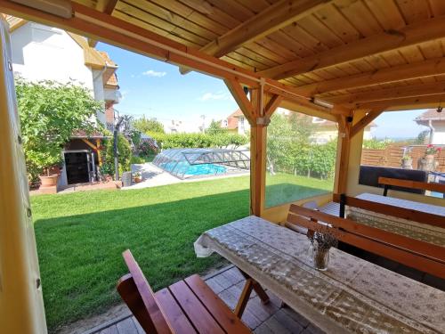 pérgola de madera con mesa y sillas en el patio en Landhaus Forrás 2, en Balatonfüred