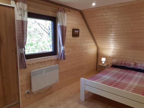 a room with a bed in a log cabin at Domek na Pętli in Hoczew