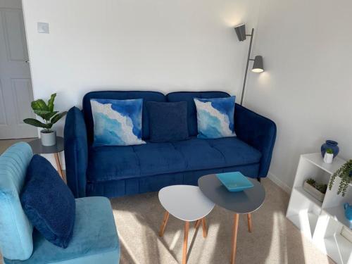 a living room with a blue couch and a table at Close to beach. Two bed compact flat. in Hunstanton