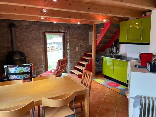 eine Küche mit einem Holztisch und einer Treppe in der Unterkunft Rustico a Roveredo GR in Roveredo