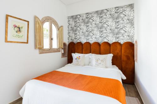 a bedroom with a large bed with an orange blanket at Riad Zyo in Rabat