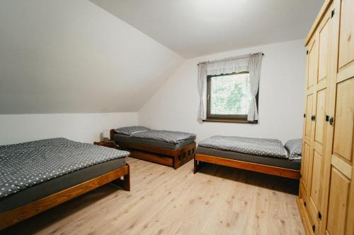 um quarto com três camas e uma janela em Apartmán Na Palouku Povrly em Povrly