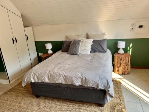 a bedroom with a bed and a green wall at Cosy City Cottage in Gaborone