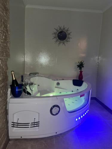 a white bath tub with a bottle of champagne at AUX PORTES DE LA CAMARGUE STUDIO BALNEO PISCINE in Tarascon