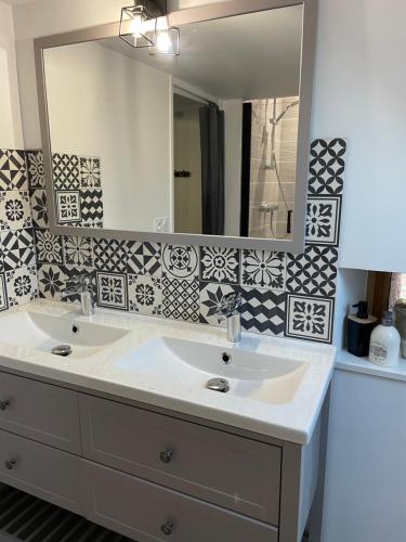 ein Badezimmer mit 2 Waschbecken und einem Spiegel in der Unterkunft Villa avec jaccuzi in Noailhac