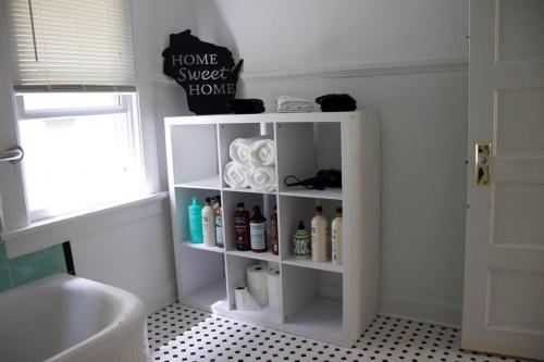 a bathroom with a white shelf with products on it at Cute yellow 2-BR bungalow w/free garage, free WiFi in Milwaukee