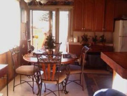 a kitchen with a table and chairs in a kitchen at BEAR CABIN GETAWAY!!!(SPA) Pet Friendly Backyard in Big Bear City
