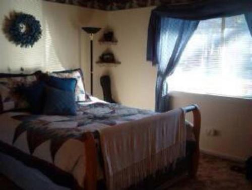 a bedroom with a bed and a window at BEAR CABIN GETAWAY!!!(SPA) Pet Friendly Backyard in Big Bear City
