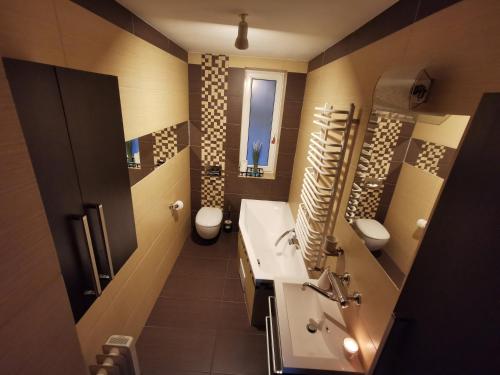 een badkamer met 2 wastafels en een toilet en een wastafel bij DOMAGAŁA Domek z kominkiem in Łagów