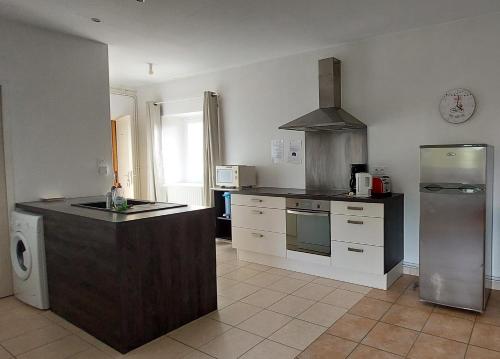 a kitchen with a refrigerator and a counter in it at La Ginelle - Appartement Bocage in Airoux