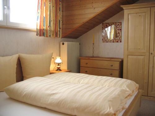 a bedroom with a white bed with a wooden ceiling at Pony-Ziegen-Hasen-Ranch Bichlbach in Bichlbach