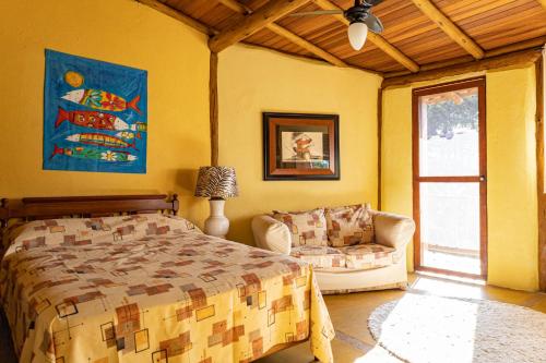 1 dormitorio con cama, sofá y ventana en Sea View Tropical Nature, en Ilhabela