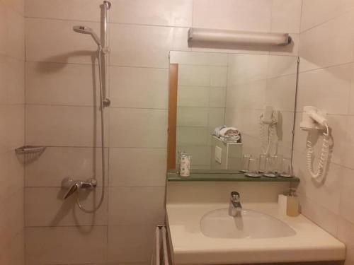 a bathroom with a sink and a shower with a mirror at Kupreška Bajka in Kupres