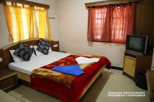 een slaapkamer met een bed en een tv. bij Sri Krishna residency in Ooty