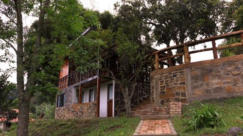 a stone building with a balcony on top of it at FINCA CELESTIAL in Pacho