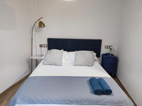 a bedroom with a bed with two blue pillows on it at La Cartería de Trabanca in Trabanca