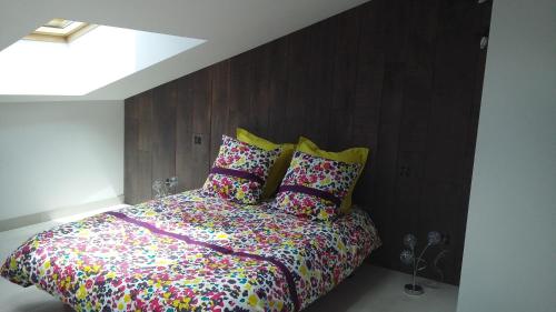 1 dormitorio con 1 cama con sábanas y almohadas coloridas en Maison moderne proche RN4, 