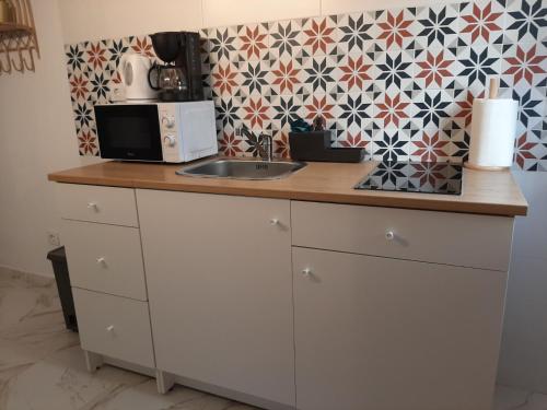a kitchen counter with a microwave and a sink at Santa Marta in Martos