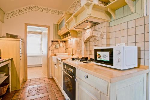 La cocina está equipada con fogones y microondas. en Apartma Koledniki, en Bled