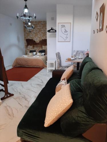 a living room with a green couch and a bed at San Amador in Martos