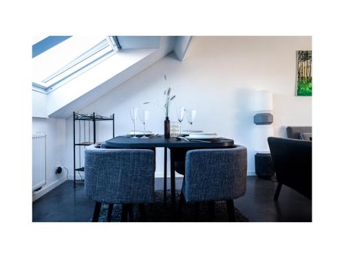 a dining room with a black table and chairs at Central Perk Apartments-Antwerp in Antwerp