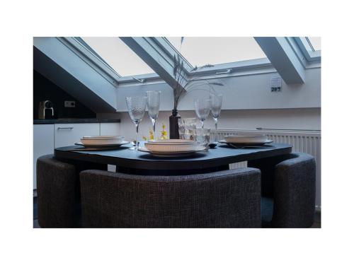 a dining room table with chairs and wine glasses at Central Perk Apartments-Antwerp in Antwerp
