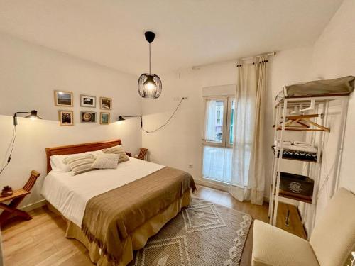 1 dormitorio con 1 cama, 1 silla y 1 ventana en El rincón del Indiano, en Santander
