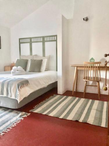 a bedroom with a bed and a table and a rug at Monte da Oliveirinha in Évora