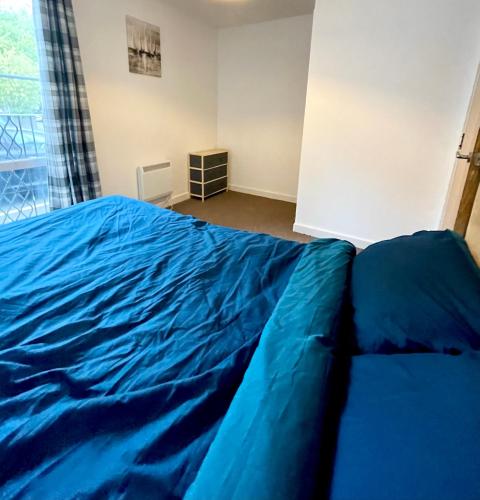 a large blue bed in a room with a window at Town centre flat in Darlington (free Parking) in Darlington