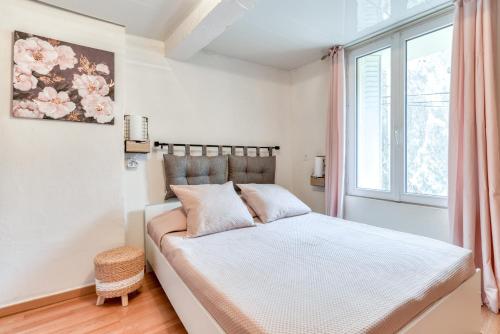 a bedroom with a bed with a large window at Le petit rubis d'Ouveillan in Ouveillan