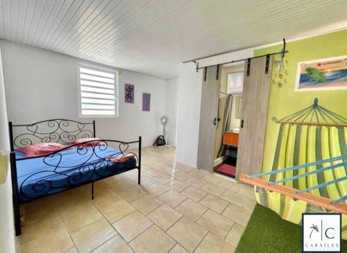 a bedroom with a bed and a door to a room at Maison de Vacances BELIOSEA Martinique 14 Rue d'Anjou in Saint-Pierre