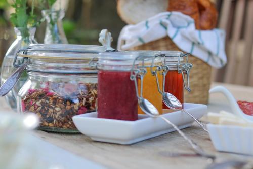 two jars of jam on a table with spoons at Villa Balthazar in Búzios