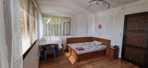 a bedroom with a bed and a table in it at Bungalow GHP-B in Varna City