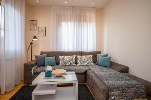 a living room with a brown couch and a table at Kalman Iskra in Zlatibor