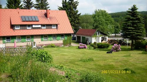 uma casa com um telhado solar num quintal em Ferienhaus am Rennsteig-Pension zur Wetterwarte em Brotterode