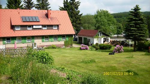 a house with a solar roof on a yard at Ferienhaus am Rennsteig-Pension zur Wetterwarte in Brotterode-Trusetal