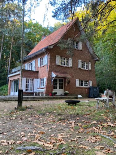 una gran casa de ladrillo en medio de un parque en Les Barolins en Rotselaar