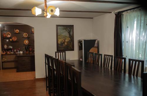 una sala da pranzo con un lungo tavolo e sedie di Casa Mario a Dragoslavele