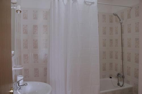 La salle de bains est pourvue d'un lavabo et d'une douche avec rideau de douche. dans l'établissement Ivone Madeira Guest House, à Funchal