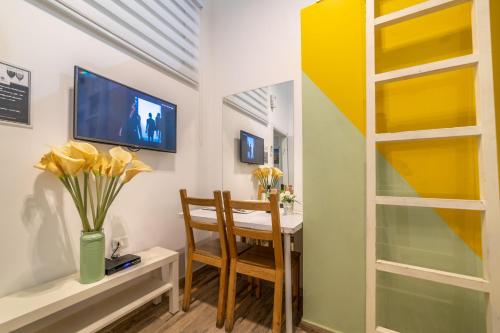 a dining room with a table and a tv at Paamonim Studios in Jerusalem