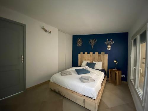 1 dormitorio con 1 cama con pared azul en Maison de ville en plein de cœur de Bagnols/Cèze, en Bagnols-sur-Cèze