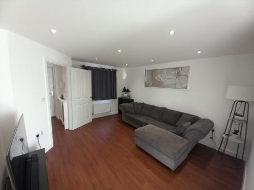 a living room with a couch and a television at Modern home with Netflix, NowTV & 2private parking in East Tilbury