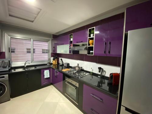 cocina púrpura con fregadero y fogones en Riverside Tétouan, en Tetuán