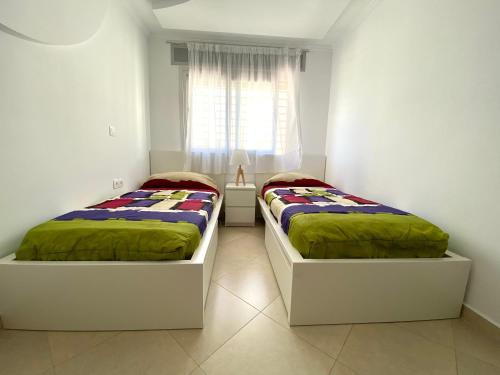 2 nebeneinander sitzende Betten in einem Schlafzimmer in der Unterkunft Riverside Tétouan in Tétouan