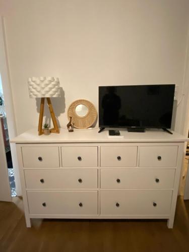 a white dresser with a flat screen tv on top at Belle Chambre Privée - Salle de bain - Jardin - Wifi - Cuisine partagée - in Wissembourg