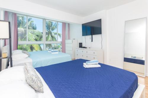 a bedroom with two beds and a large window at Girasole Apartments in Miami Beach