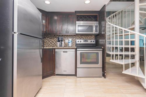 a kitchen with stainless steel appliances and wooden cabinets at Girasole Apartments in Miami Beach